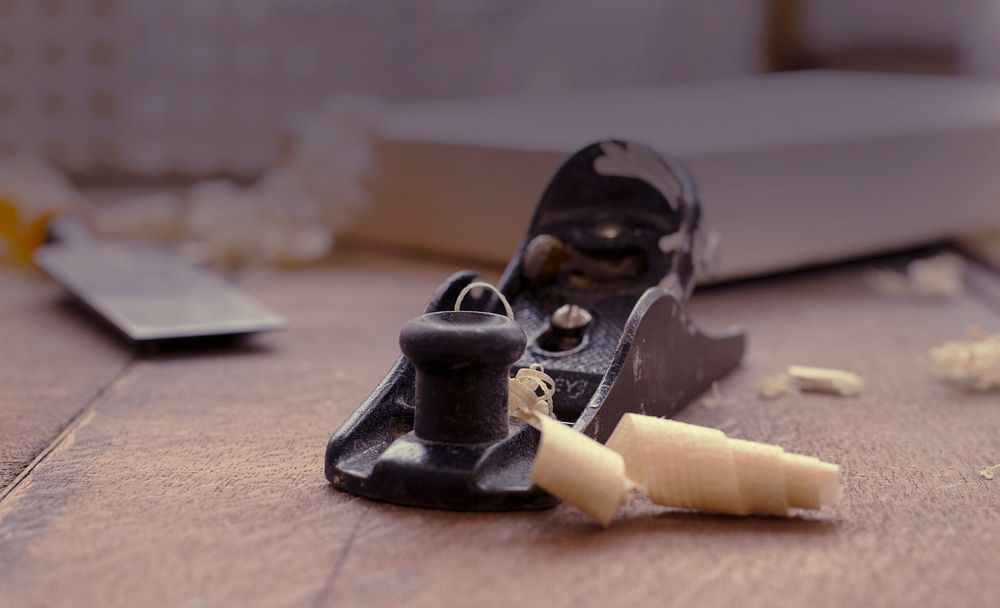 Slivers of shaved wood next to a hand plane. Original public domain image from Wikimedia Commons
