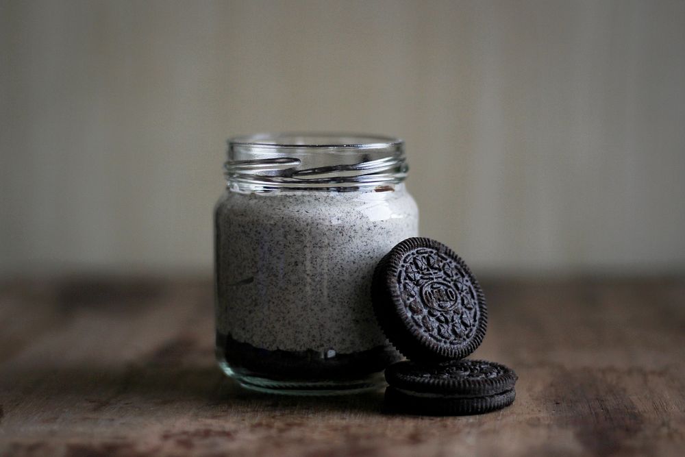 Mason jar of a sweet dessert with oreo cookies on a table. Original public domain image from Wikimedia Commons