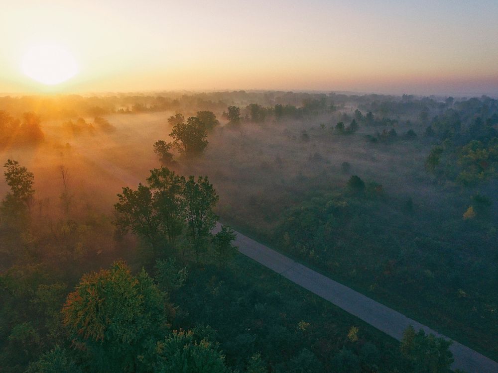 Drone view of misty countryside and through road at dawn-or-dusk in Flint, Michigan. Original public domain image from…