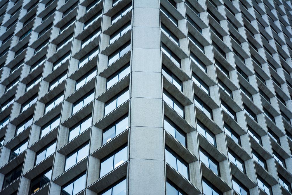 Macro view of reflective windows in a grid pattern on a skyscraper facade. Original public domain image from Wikimedia…