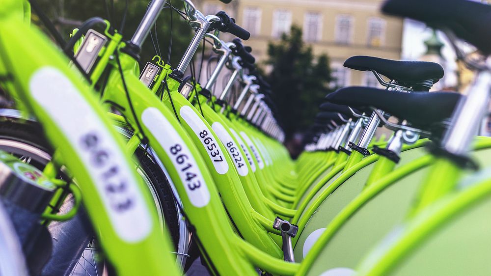 Line of green rental bikes form a v pattern. Original public domain image from Wikimedia Commons
