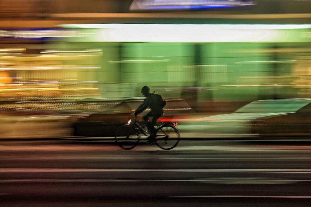 Long exposure photo of a man on a bicycle at night in Albenga, Liguria, Italy.. Original public domain image from Wikimedia…