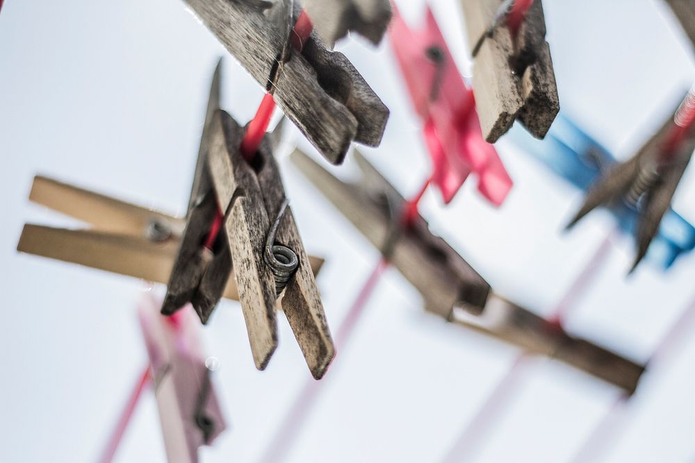 Rustic clothespins hung on a laundry line. Original public domain image from Wikimedia Commons
