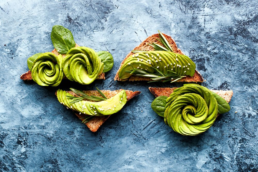 Pieces of toast with avocado arranged in the shape of a rose on them. Original public domain image from Wikimedia Commons