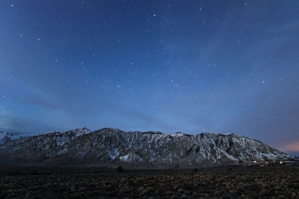 Starry night sky over a snow-topped mountain range near Mammoth Lakes. Original public domain image from Wikimedia Commons
