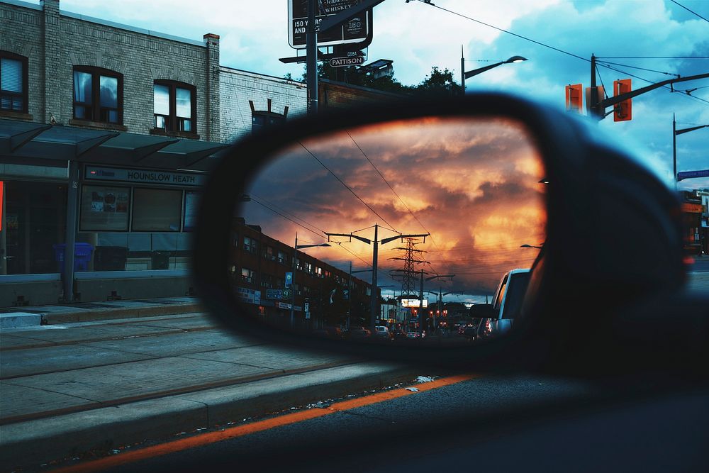 The view of an orange sky and the road from a side mirror on a car in Toronto. Original public domain image from Wikimedia…