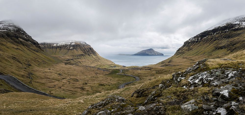 Overcast landscape view of rocky hillside valley and peaks on the Faroe Islands. Original public domain image from Wikimedia…