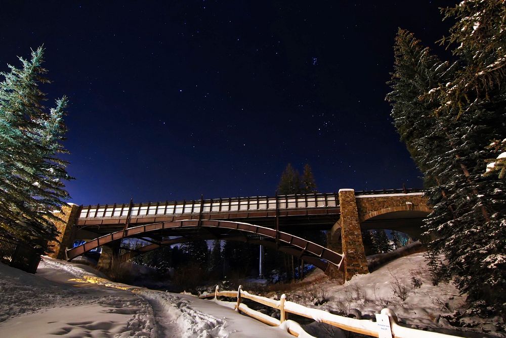 A bridge crossing over a fenced road at the Vail Ski Resort in Colorado. Original public domain image from Wikimedia Commons