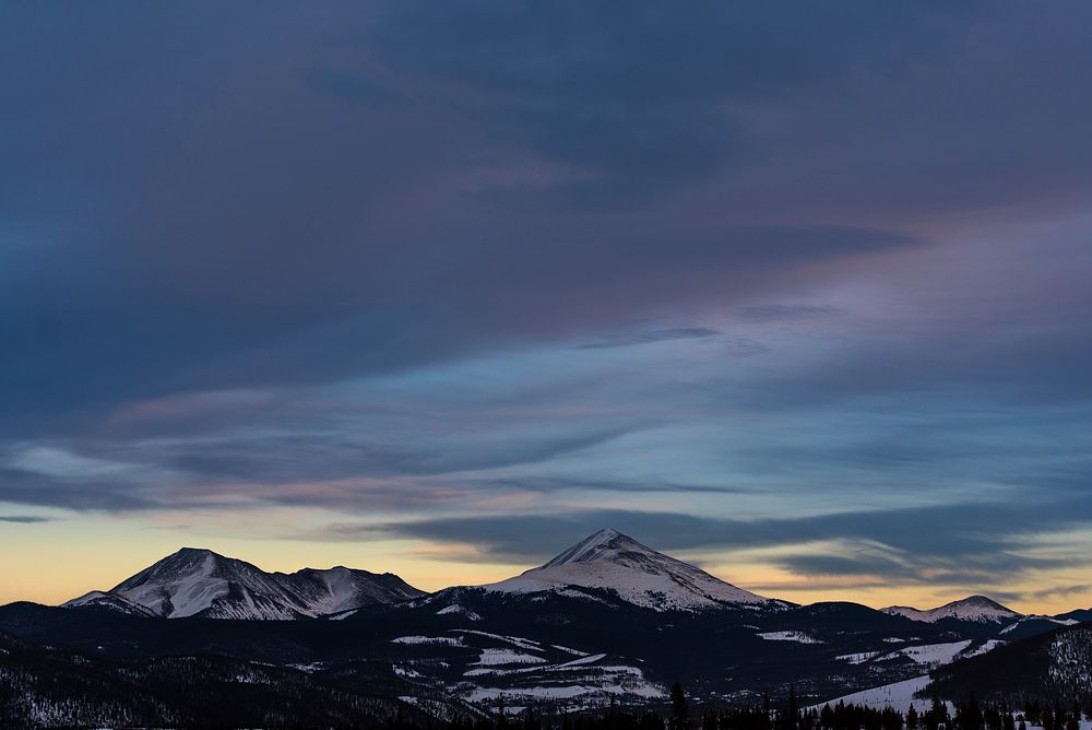 Dark evening clouds over snow-capped mountain peaks in Silverthorne. Original public domain image from Wikimedia Commons