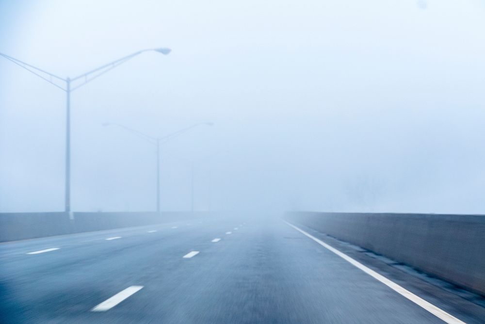 Foggy empty highway with streetlights on a morning drive. Original public domain image from Wikimedia Commons