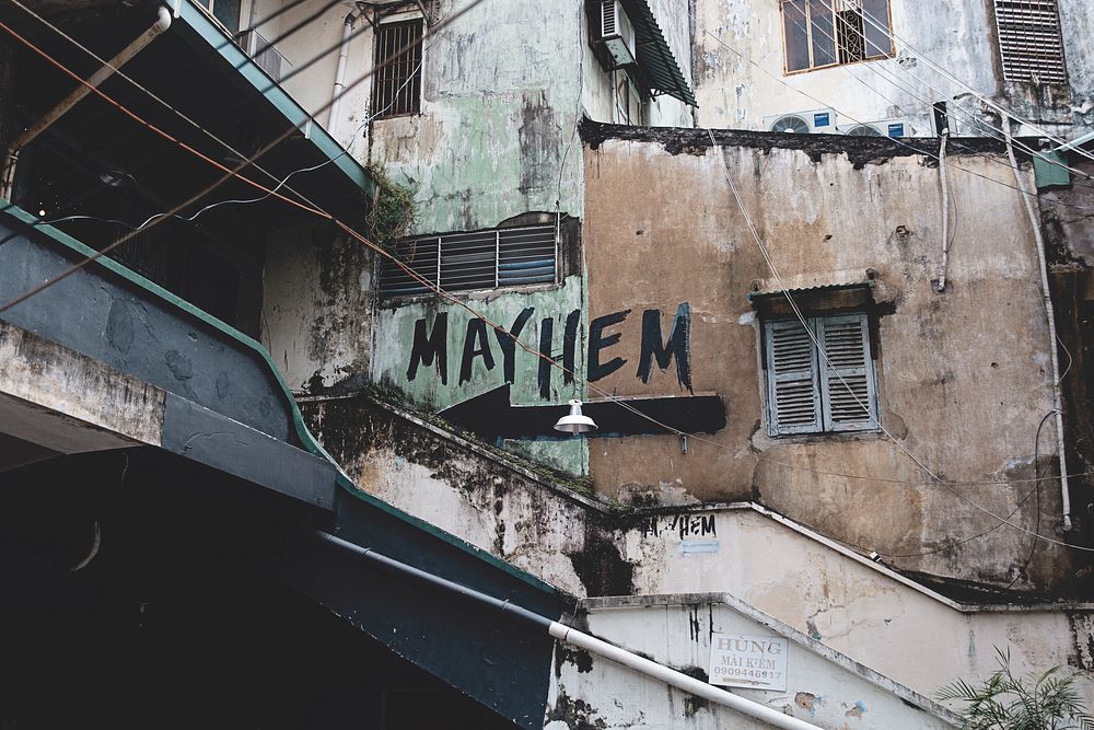 The exterior view of an urban building with an arrow and a mayhem text written on it in Ho Chi Minh City.. Original public…