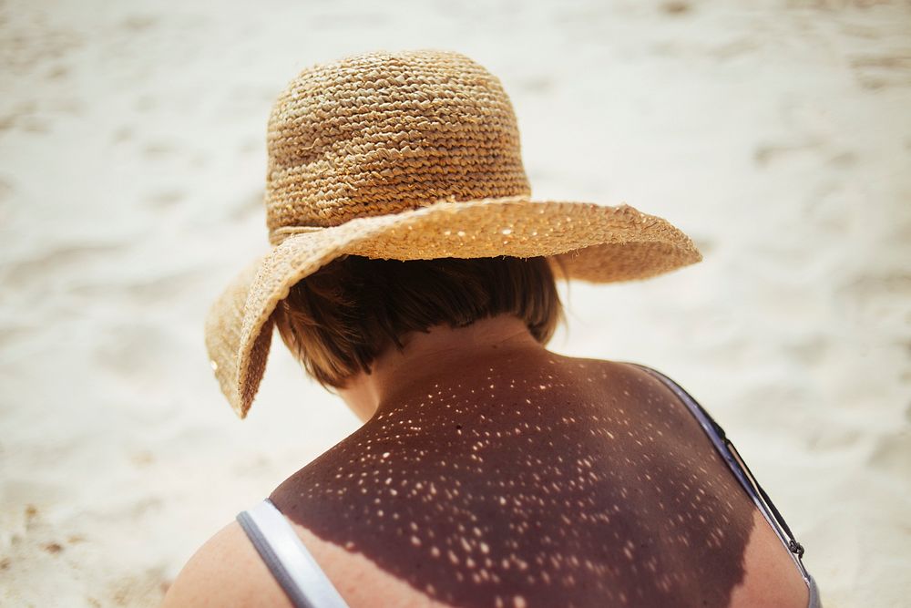 Woman wearing a sunhat by the beach. Original public domain image from Wikimedia Commons