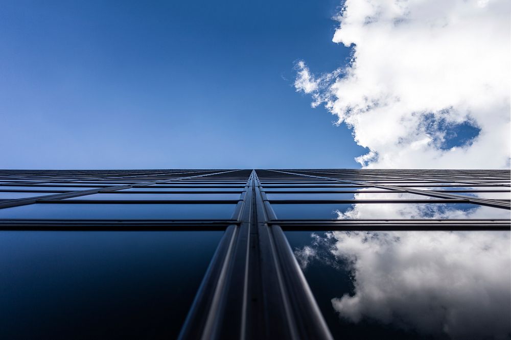 Clouds and blue sky reflected in windows of a modern building. Original public domain image from Wikimedia Commons