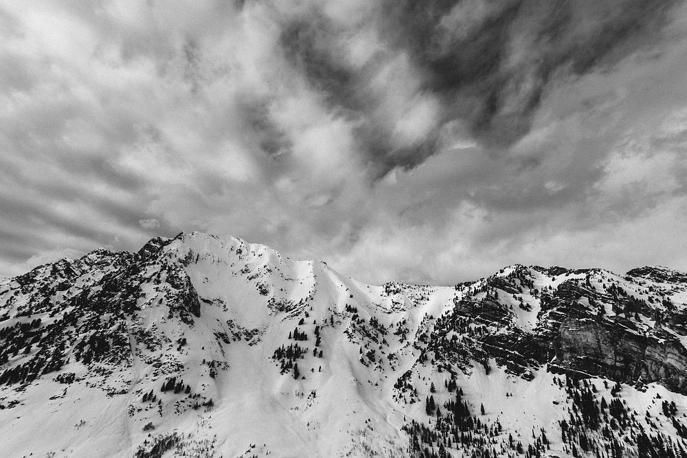 Black and white shot of snow mountains and cloudy sky. Original public domain image from Wikimedia Commons