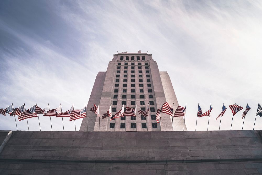 A long row of American flags on a concrete ledge near Los Angeles City Hall. Original public domain image from Wikimedia…
