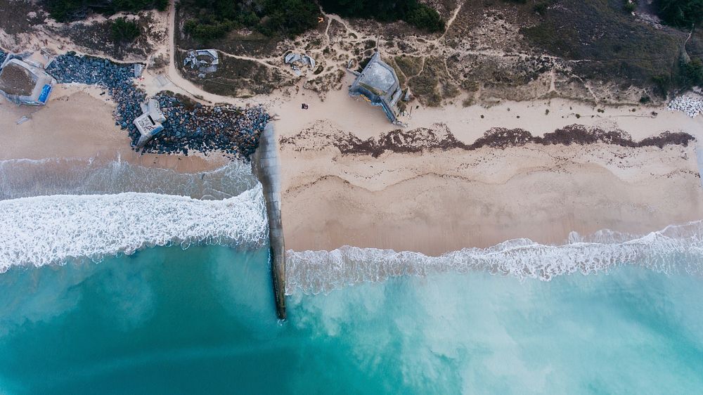 Drone aerial view of concrete constructions on the sand beach at Plage du Petit Bec. Original public domain image from…