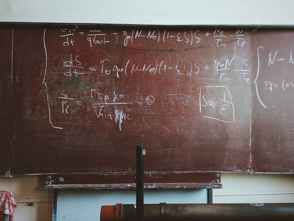 Equations written in chalk on a worn-out blackboard. Original public domain image from Wikimedia Commons