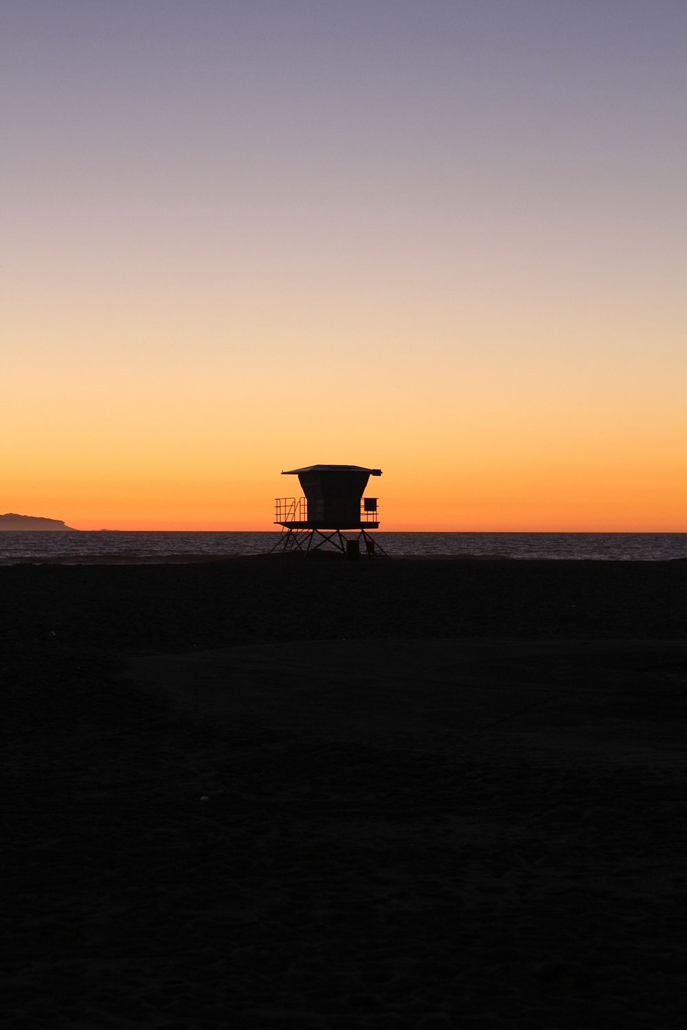 A silhouette of a lifeguard station on a deserted Huntington Beach at sunset. Original public domain image from Wikimedia…
