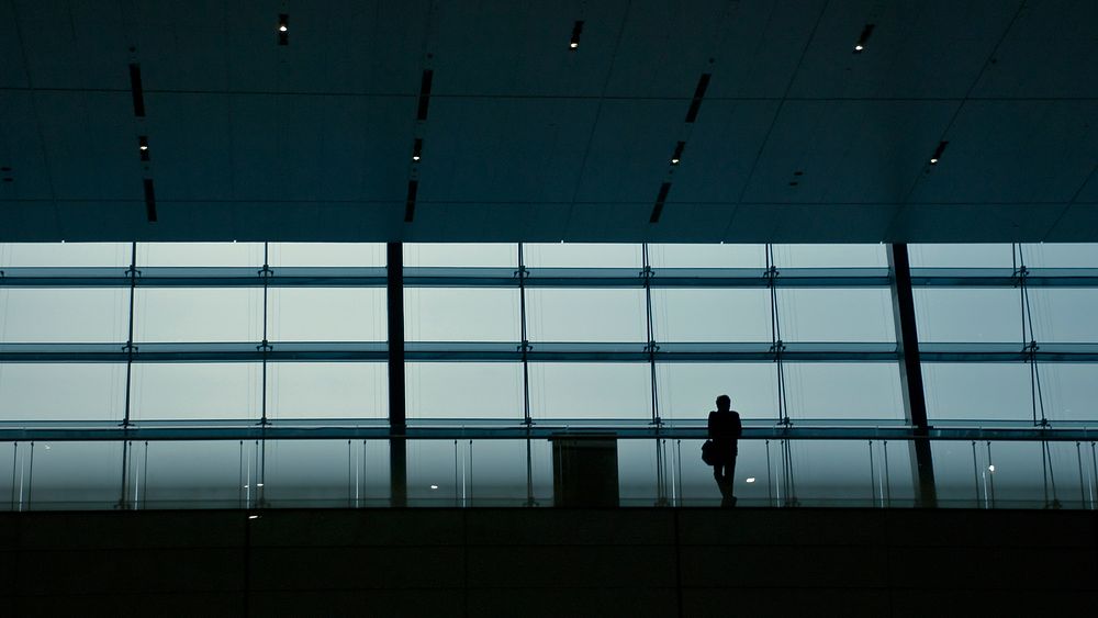 A silhouette of a person in a dark railway terminal. Original public domain image from Wikimedia Commons