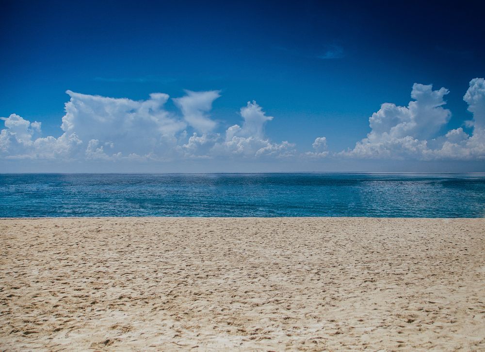 A sandy seashore along a bright blue ocean in Cozumel. Original public domain image from Wikimedia Commons