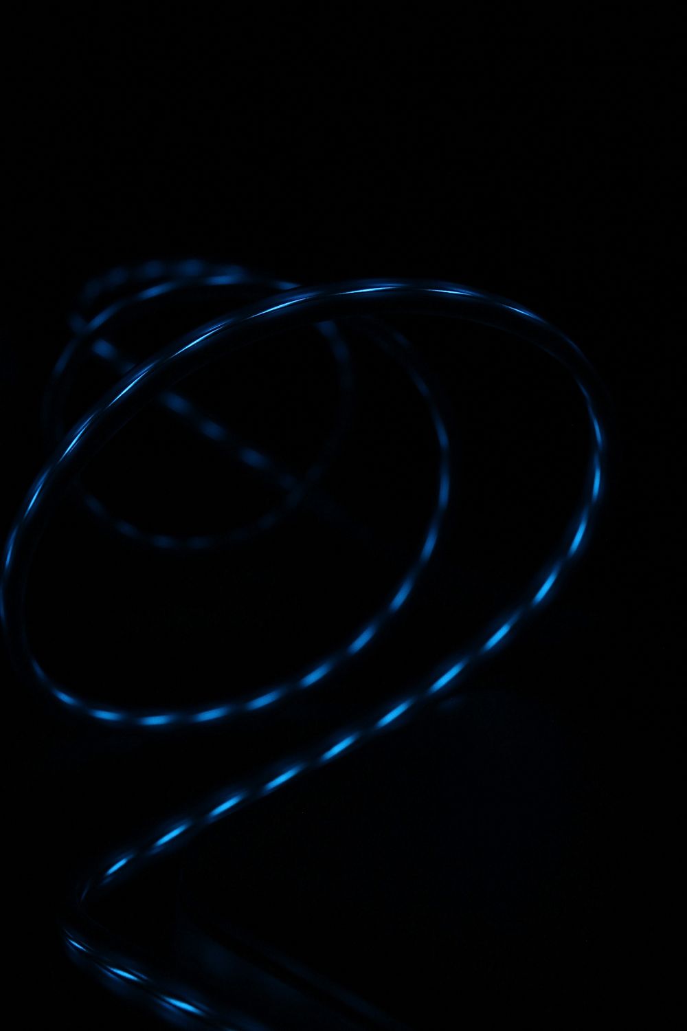 Blue light reflected in the glossy surface of a swirling wire. Original public domain image from Wikimedia Commons