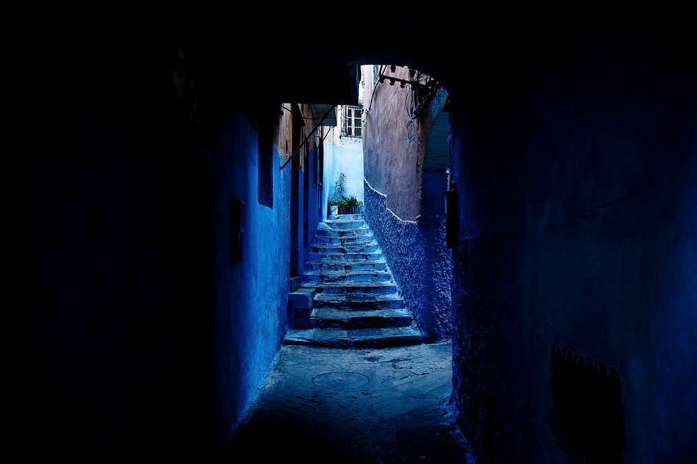 A small, blue staircase at end of tunnel leading towards light. Original public domain image from Wikimedia Commons