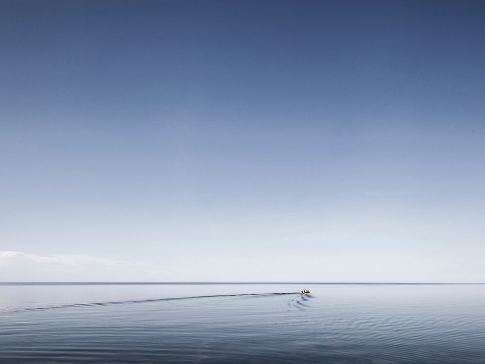 Small boat, sea, ripples, sky. Original public domain image from Wikimedia Commons