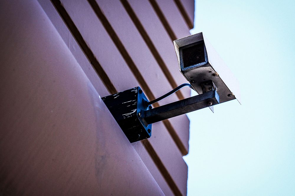 A security camera on a building facade. Original public domain image from Wikimedia Commons