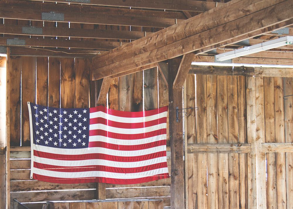 An American flag hanging in a wooden barn. Original public domain image from Wikimedia Commons
