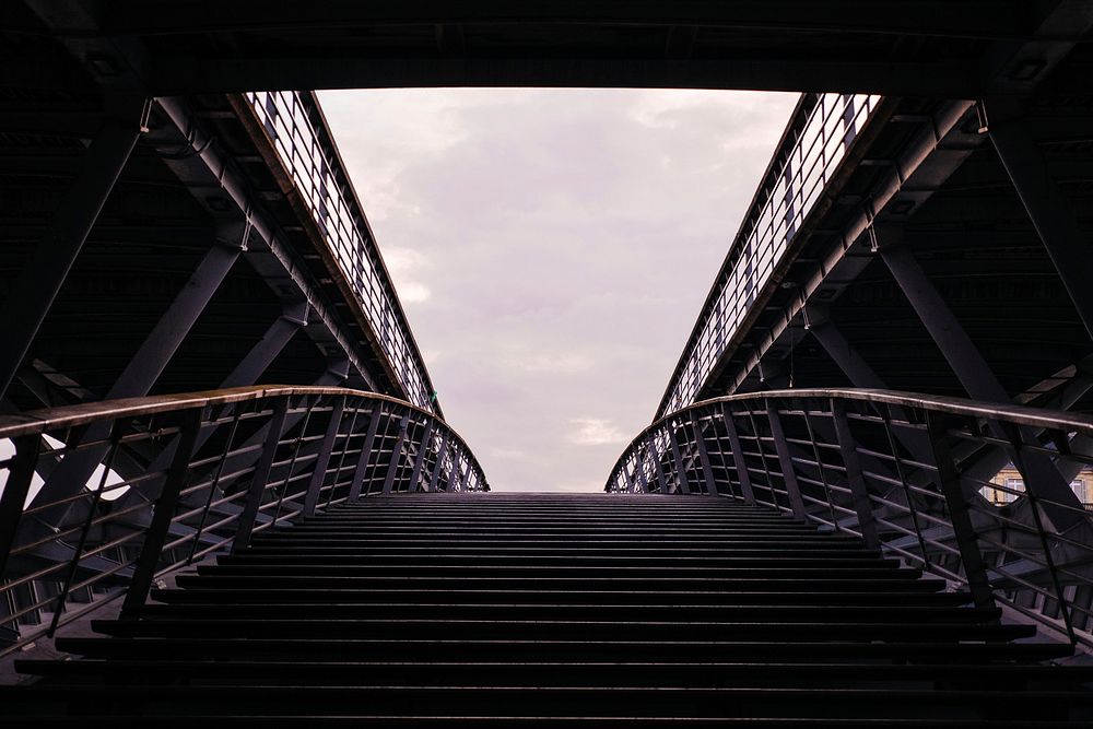 A symmetrical shot of stairs leading up to a bridge. Original public domain image from Wikimedia Commons