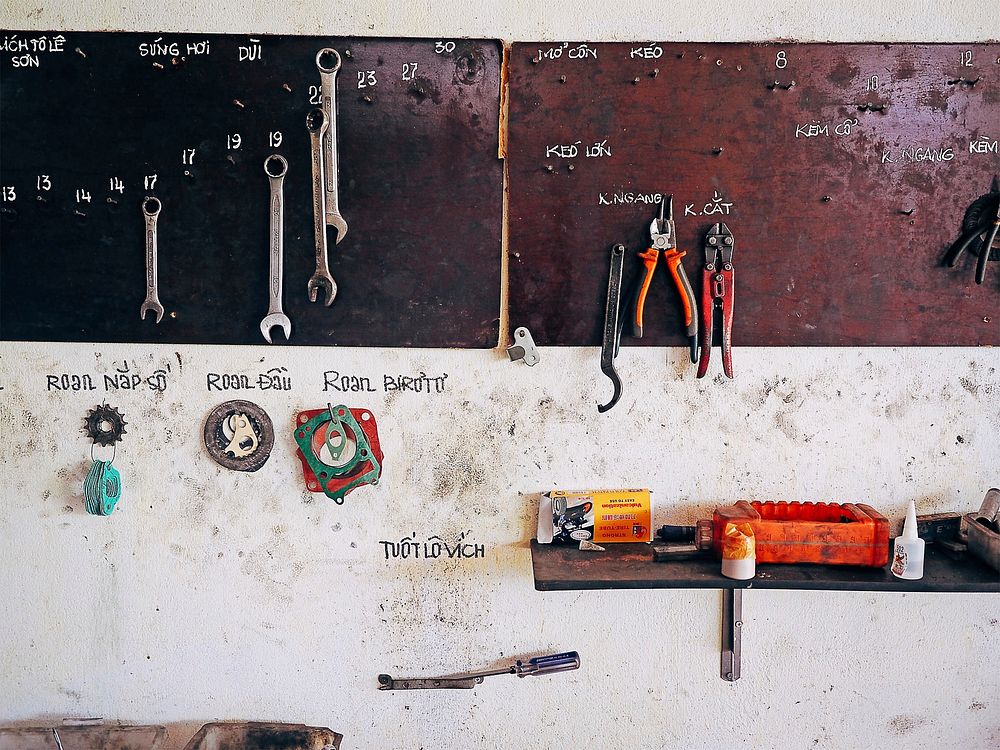 A workshop wall with handwriting to label the different tools. Original public domain image from Wikimedia Commons