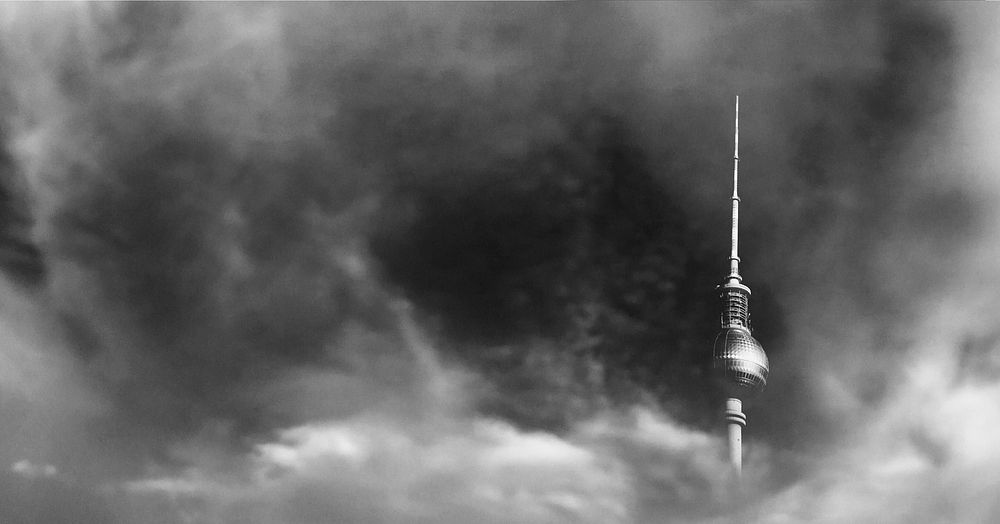 The Fernsehturm tower in Berlin shrouded in gray clouds. Original public domain image from Wikimedia Commons