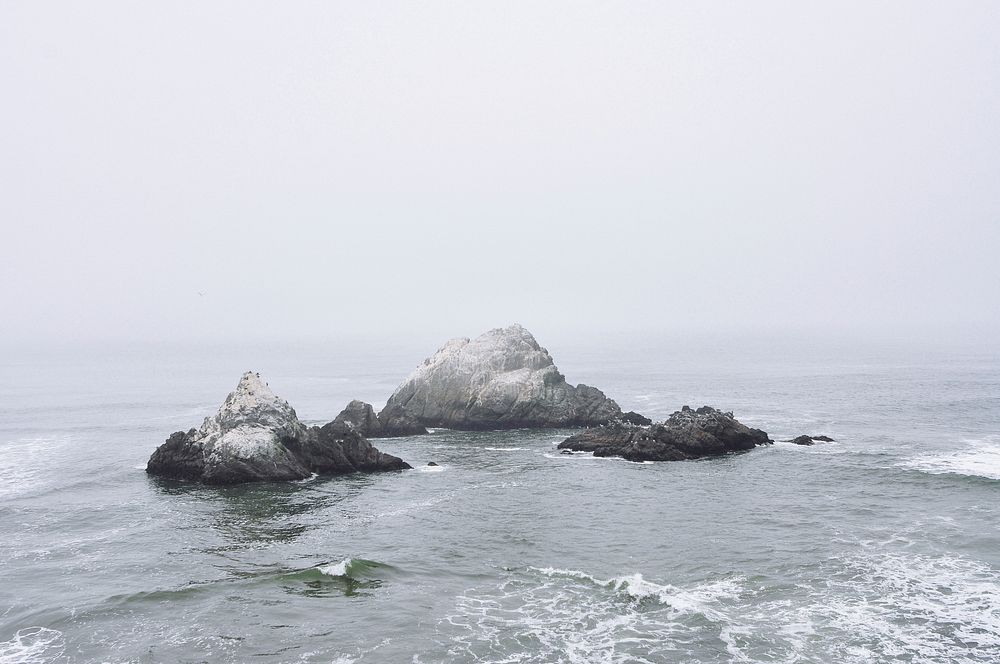 Foggy sky over rock formations in the ocean. Original public domain image from Wikimedia Commons