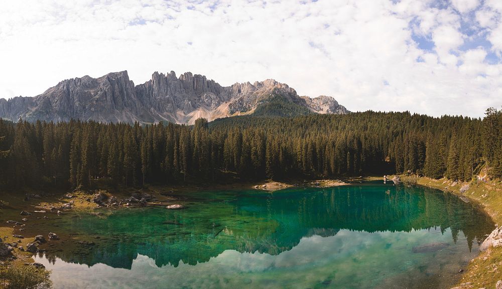 The emerald-green Lake of Carezza near tall granite peaks. Original public domain image from Wikimedia Commons