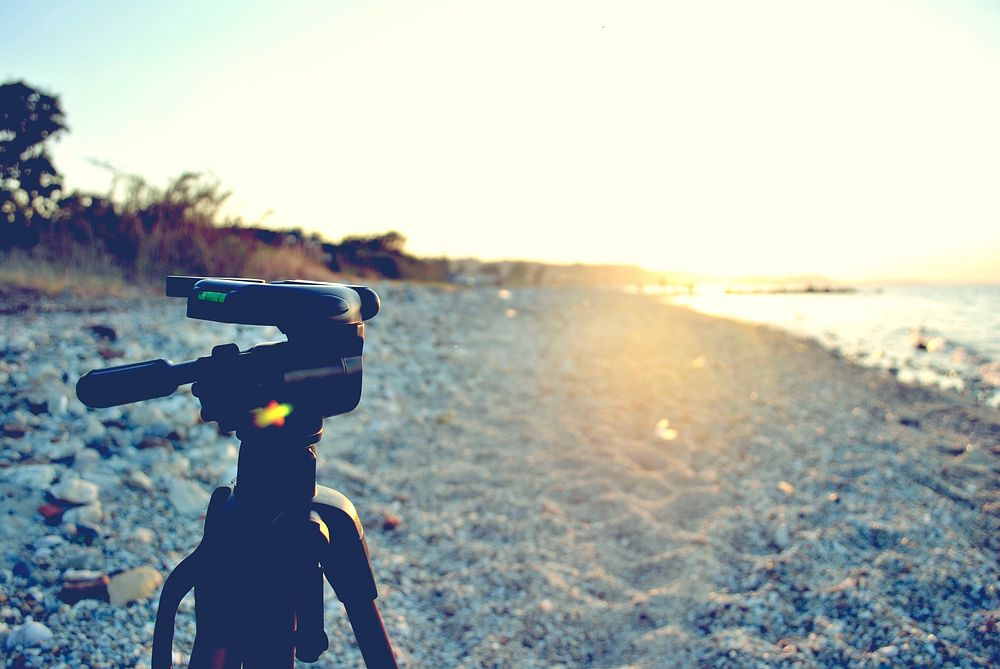 Camera tripod on a rock pebble beach at sunset in Halkidiki. Original public domain image from Wikimedia Commons