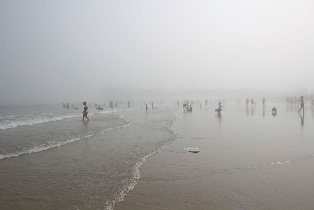 People relishing the fog at mist covered beach. Original public domain image from Wikimedia Commons