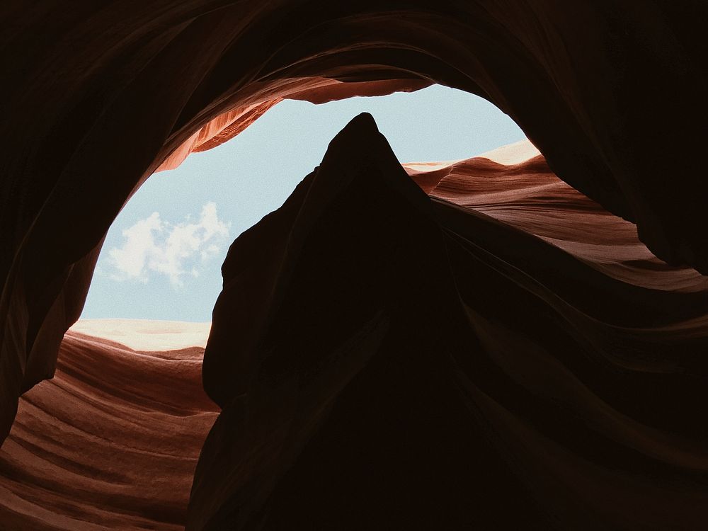 Sun shines through an opening in a sand cave. Original public domain image from Wikimedia Commons