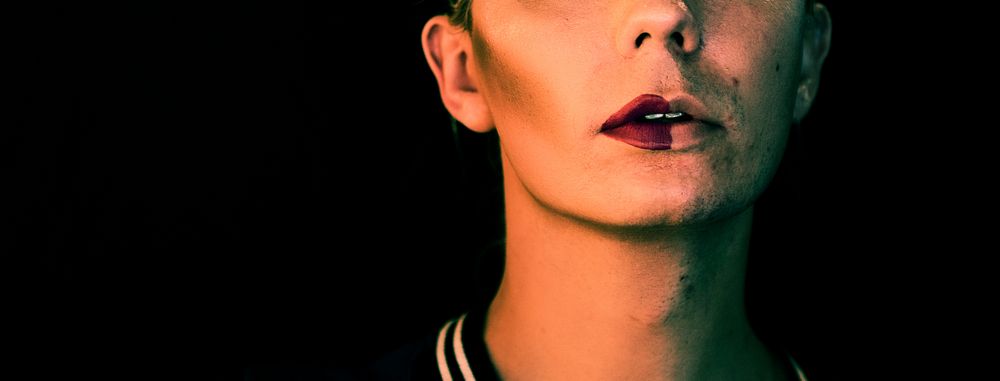 Portrait of a transgender woman with half a makeup on the face social banner