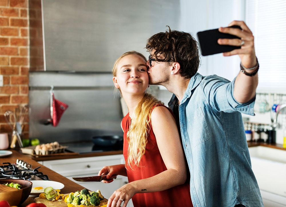 Man taking a selfie with his wife in the kitchen