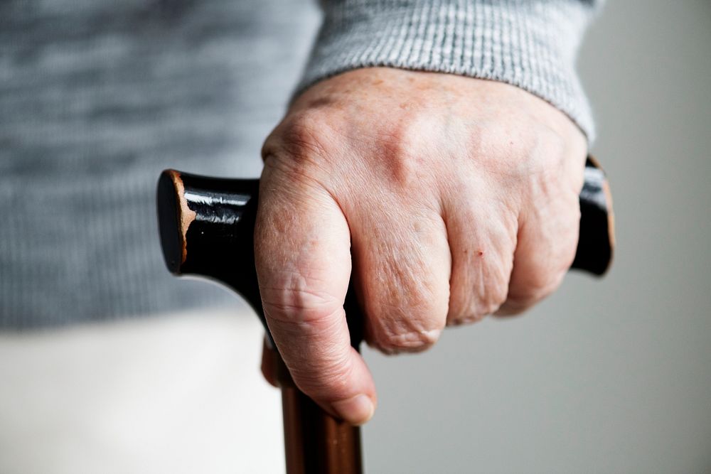 Closeup of elderly hand holding a walking stick