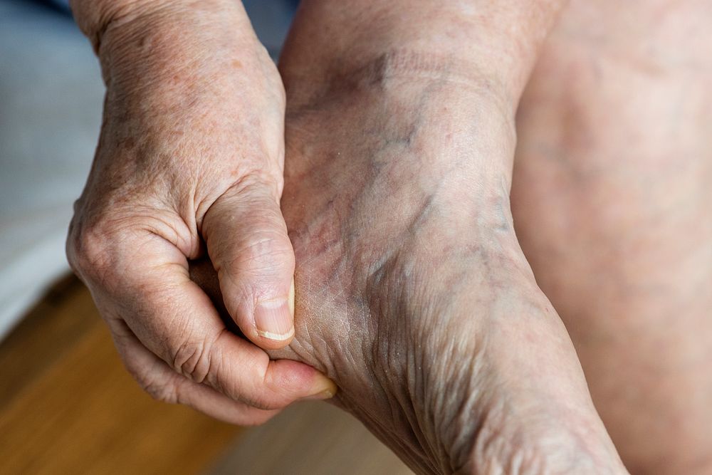 Closeup of elderly hand massaging foot