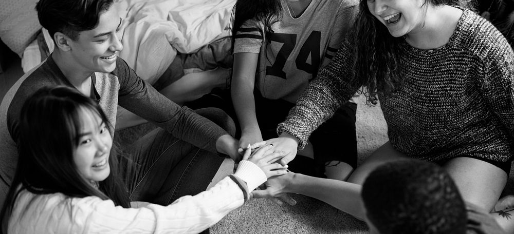 Group of teenagers in a bedroom putting their hands together community and temwork concept