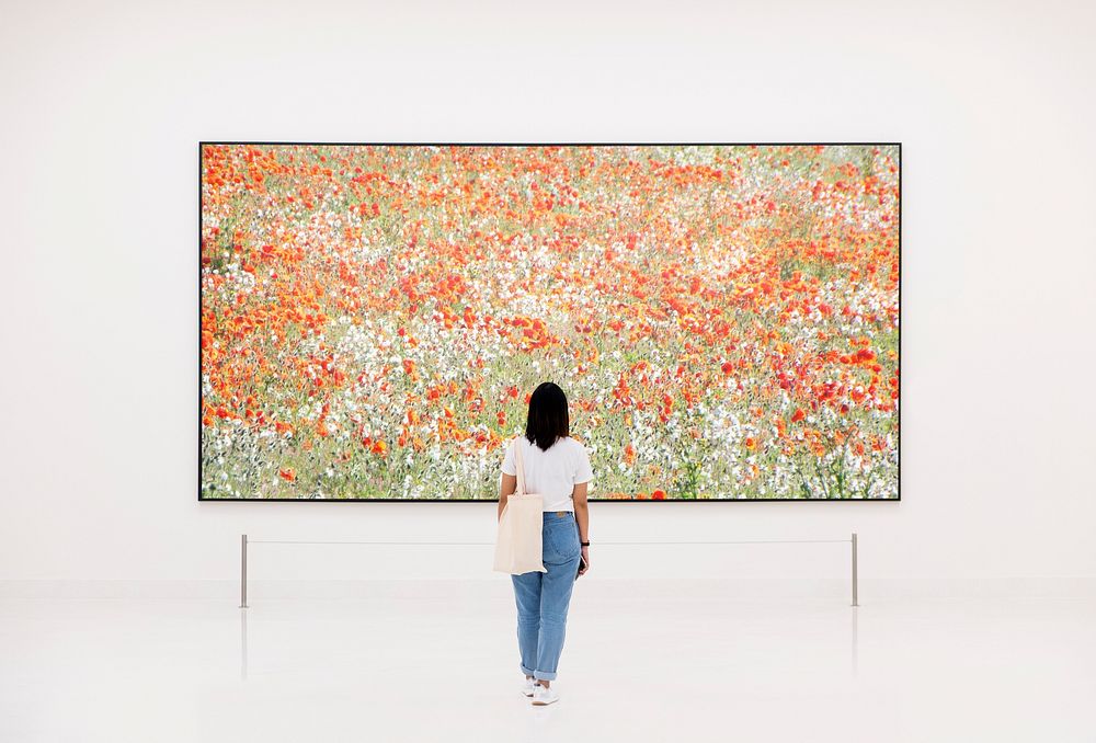 Woman enjoying art exhibition, flower picture frame