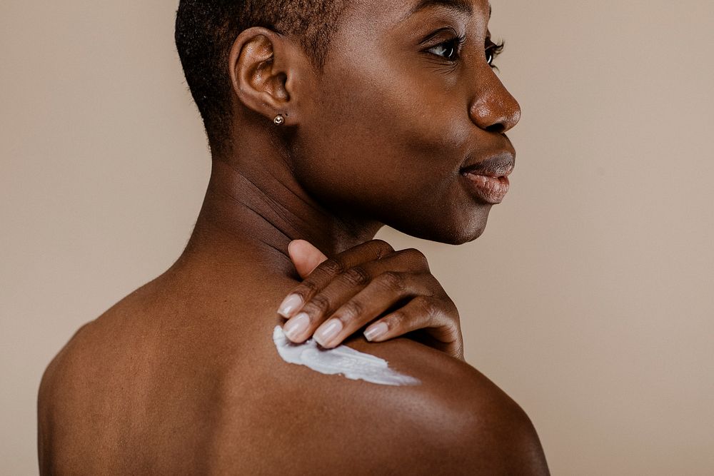 Black woman applying body cream