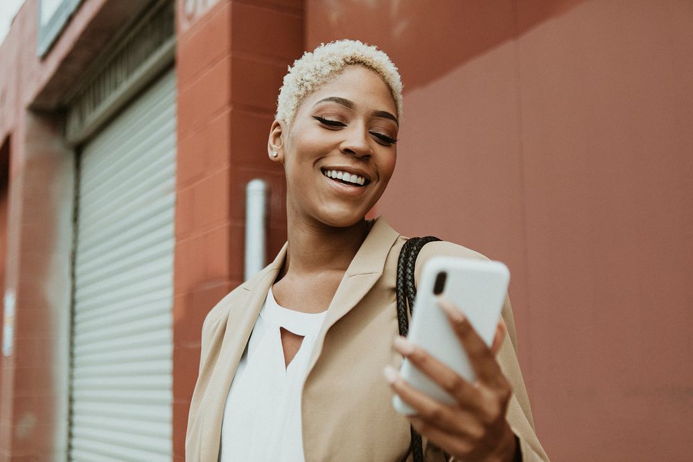 Happy black businesswoman using her smartphone