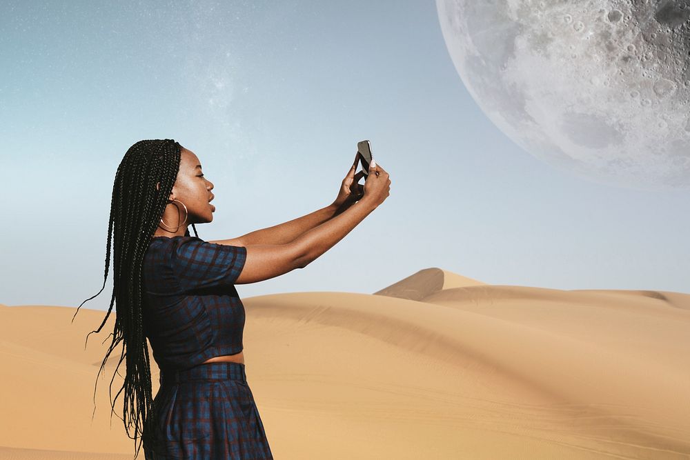 Black woman taking a photo on a desert