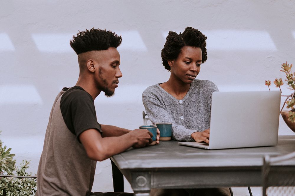 Black people working on a laptop in the garden