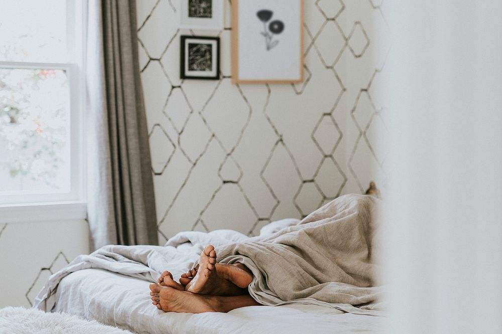 Black couple with their feet under the blanket