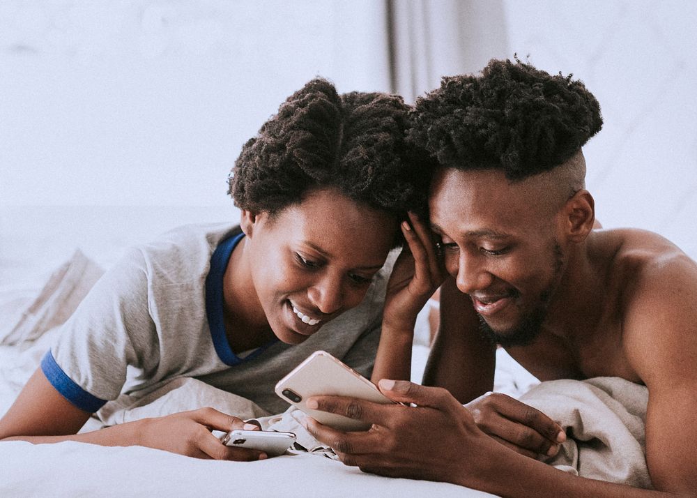 Happy black couple playing on a smartphone together