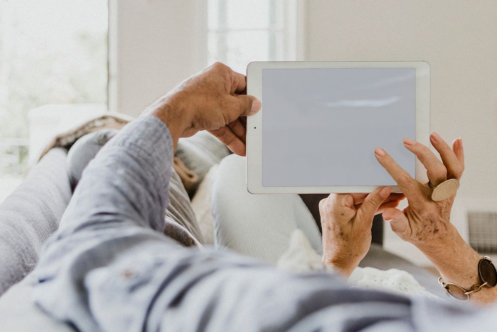 Elderly couple using a tablet on a couch